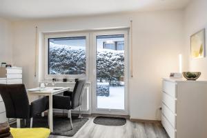 a room with a table and chairs and a window at Schwarzwaldblick K App 4 mit Pool in Schönwald