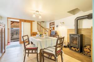 a dining room with a table and a fireplace at Chalet Kunterbunt in Langenwetzendorf