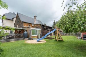 a yard with a slide in front of a house at Chalet Kunterbunt in Langenwetzendorf