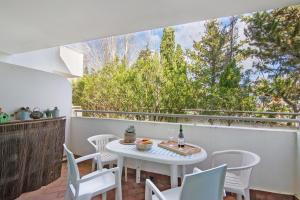 a patio with a white table and chairs on a balcony at Prainha Paradise - Algarve in Alvor