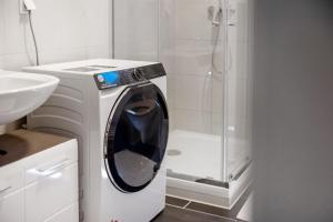 a washing machine in a bathroom with a shower at Ferienwohnung in München Eg in Munich +17 photos