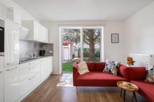 a living room with a red couch and a kitchen at Ferienwohnung in München Eg in Munich