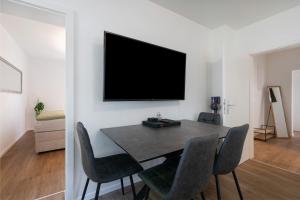 a dining room with a table and a television on a wall at Ferienwohnung in München Eg in Munich