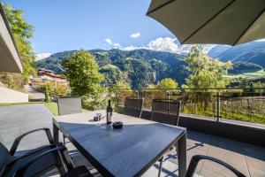 a table and chairs on a balcony with a view of mountains at Chalet Riad in Saltusio