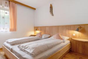 a bedroom with a large bed with white sheets at Apartment Stuflesser in Laion