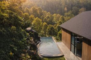 a house with a swimming pool next to a forest at Bali Barn Village in Munduk +93 photos