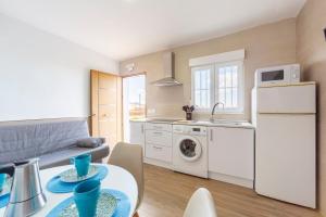 a kitchen and living room with a table and a refrigerator at Nido in Níjar