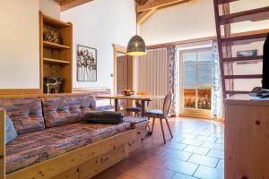 a living room with a couch and a table at Häuslerhof App Tilia in Villabassa +21 photos