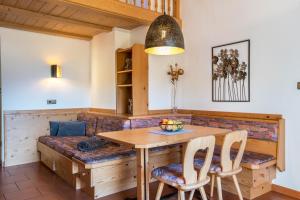 a dining room with a wooden table and chairs at Häuslerhof App Tilia in Villabassa