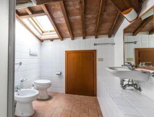 a bathroom with a toilet and a sink and a mirror at Podere Simonetta - A1 in Cecina +13 photos