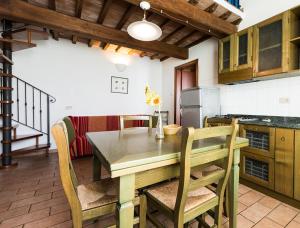 a kitchen with a wooden table and chairs at Podere Simonetta - A1 in Cecina