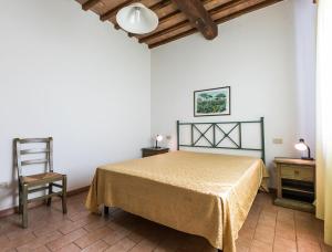 a bedroom with a bed and a chair at Podere Simonetta - A1 in Cecina