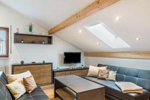 a living room with a blue couch and a tv at Haus Erichsen in Perlesreut