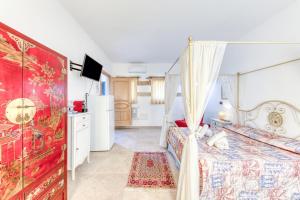 a bedroom with a canopy bed and a kitchen at Le Colonie - Pescoluse in Presicce