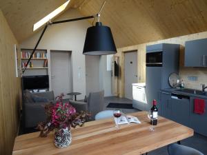 a kitchen and living room with a table with a bottle of wine at Alte Tischlerei Engelsbach in Georgenthal