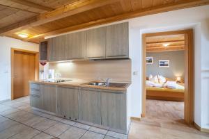 a kitchen with a sink and a bed in a room at Lingerhof Arnika in Meltina +15 photos