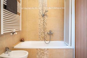 a bathroom with a bath tub and a sink at Martina's Place in Castello di Fiemme +31 photos