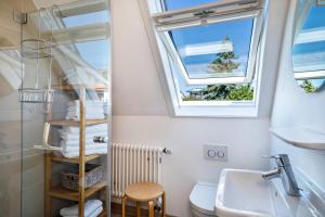 a bathroom with a sink and a toilet and two windows at Ferienhaus Immenstaad in Immenstaad am Bodensee +24 photos