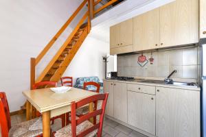 a kitchen and dining room with a table and a staircase at Il Quadrifoglio 2 in Procchio +15 photos