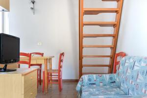 a living room with a desk with a tv and a ladder at Il Quadrifoglio 2 in Procchio