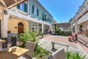 a patio with a table and chairs and buildings at Il Quadrifoglio 2 in Procchio