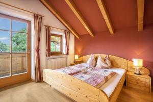 ein Schlafzimmer mit einem Holzbett und einem großen Fenster in der Unterkunft Oberplunerhof - Fewo Kronplatz in Kiens