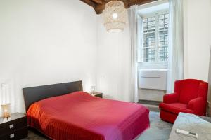 a bedroom with a red bed and a red chair at Appartamento La Naiade, Lucca in Lucca