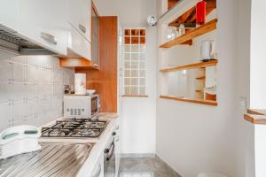 a white kitchen with a stove and a microwave at Appartamento La Naiade, Lucca in Lucca +6 photos