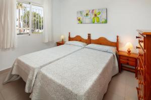 a white bedroom with a bed and a window at Apartamento M 1 in Torrox Costa +24 photos