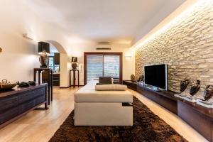 a living room with a couch and a tv at Villa Rokkaria in Villasimius