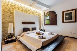 a bedroom with a bed and a brick wall at Villa Rokkaria in Villasimius