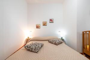 a bedroom with a bed with two pillows on it at Gaia Casa Vacanze in San Giovanni Suergiu