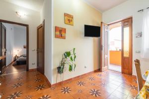 a living room with a tv on the wall at Gaia Casa Vacanze in San Giovanni Suergiu