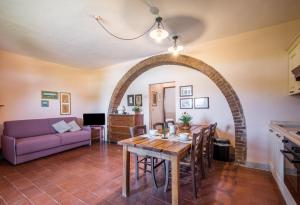 a living room with a table and a purple couch at Podere del Pereto Bio- 203 in Rapolano Terme
