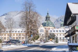 a building with a green dome on a snowy street at Ferienwohnung Gschwand in Unterammergau