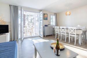 a living room with a bottle of wine on a table at La Cabine in Fouesnant