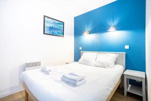 a small room with a bed with a blue wall at La Cabine in Fouesnant