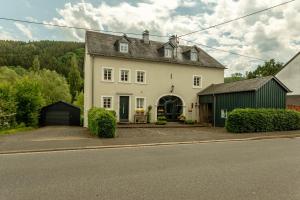 a large white house with a green garage at Ferienwohnung Happynest in Birresborn