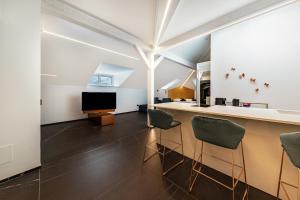 a kitchen and living room with a counter and chairs at App 304 Palazzo Cavour in Bolzano