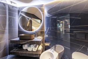 a bathroom with a round mirror and a sink at App 304 Palazzo Cavour in Bolzano