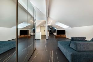 a living room with two couches and mirrors at App 304 Palazzo Cavour in Bolzano