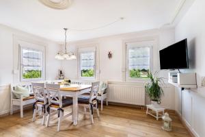 a dining room with a table and chairs and a tv at Am Döttelbach in Bad Peterstal-Griesbach
