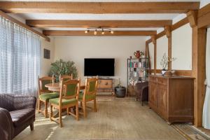 a living room with a table and a television at Hotel Garni Vitamari in Wasserburg