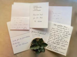 a bunch of white envelopes with a succulent at Hotel Garni Vitamari in Wasserburg
