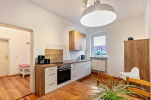 a kitchen with white cabinets and a stove top oven at Im Herzen Templins Obergeschoss in Templin +19 photos