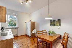 a kitchen and dining room with a wooden table at Im Herzen Templins Obergeschoss in Templin