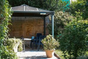 a gazebo with chairs and a table in a garden at Hotel Garni Vitamari in Wasserburg