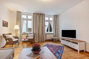 a living room with a couch and a tv at Im Herzen Templins Obergeschoss in Templin