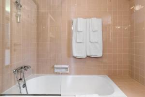 a bathroom with a bath tub with towels on the wall at Casa de Santo António Moledo in Moledo +36 photos
