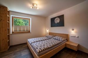 a bedroom with a bed and a window at Ferienwohnung Haus Fliri in Curon Venosta